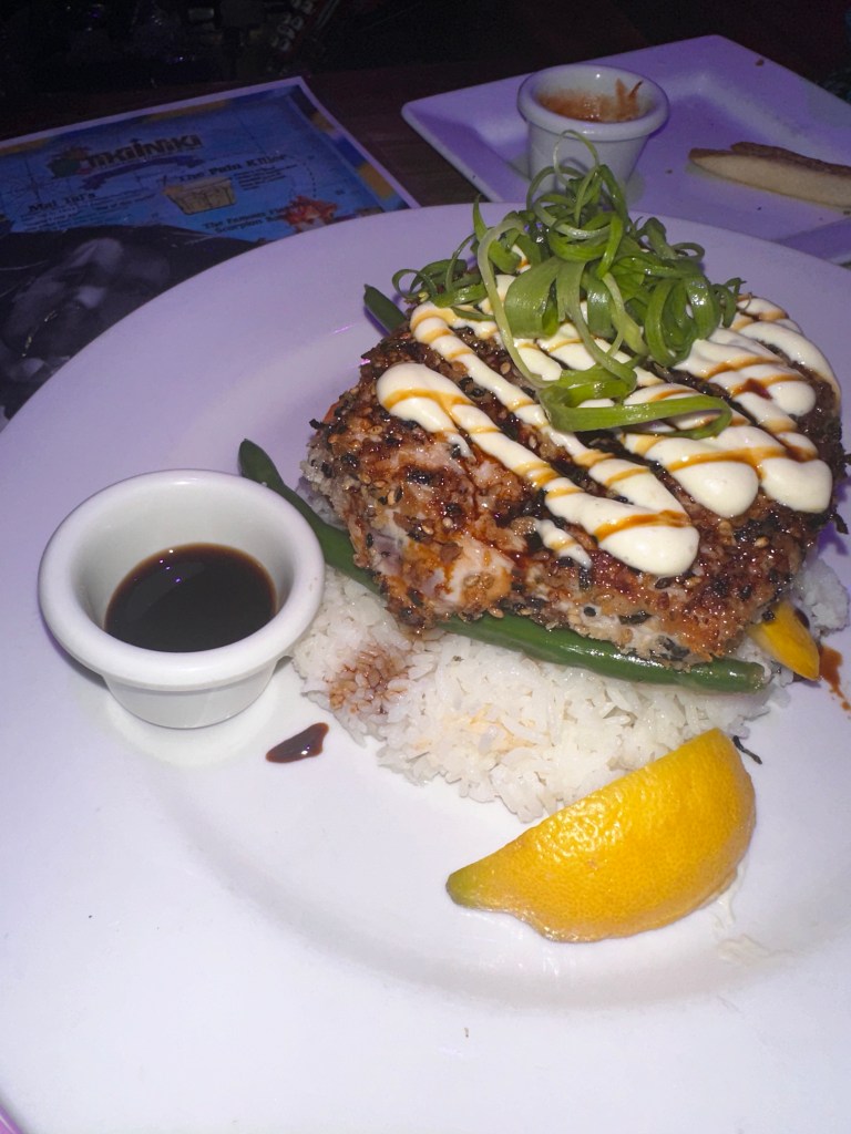 A photo of some of the best ahi tuna I've ever had, sitting on some sushi rice and topped with a spicy mayo and some seaweed